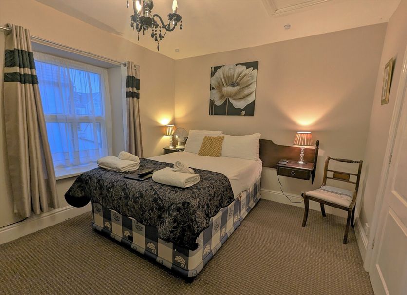 The Senarth, Llandudno: cozy guest room with double bed, bedside lamps, window and chair