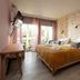 Hôtel Saint-Clair, côté Plage in La Grande-Motte bedroom with double bed, stone accent wall and balcony doors