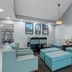 Baymont by Wyndham Tuscaloosa lounge with teal sofa, armchairs, and framed wall art in Tuscaloosa