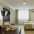 Intercity João Pessoa guest room with two beds, TV, desk, sofa and city-view window
