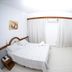 Champagnat Praia in Vila Velha guest room with bed, sofa, wall TV, and window curtains