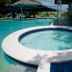 Fun Holiday Beach Resort in Negril: round whirlpool beside the pool with shaded cabana and lounge area.