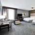 Homewood Suites by Hilton New Braunfels guest room with two beds, sofa, TV and window seating