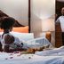 Le Plaza Hotel in Port Au Prince guest room with a couple on the bed and a bedside lamp