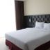 Grand Orchid Hotel Yogyakarta room with a neatly made bed, black headboard, and natural light in Depok