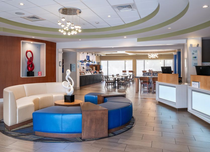 Holiday Inn Express & Suites Lakeland South lobby with seating area, front desk and dining space