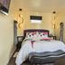 Eo Bungalows, Black Hills in Custer: cozy bed with floral bedding and an adjacent open bathroom