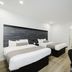 Sapphire Inn and Suites Deer Park guest room with two double beds and adjoining bathroom doorway