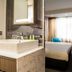 Golden Tulip Leiden Centre in Leiden: modern guest room with bed, desk, TV, and bathroom sink