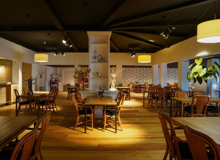 Resort Bad Boekelo in Boekelo dining room with wooden tables, chairs, and warm pendant lighting