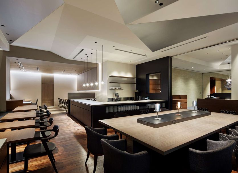 Mitsui Garden Hotel Kyobashi Tokyo restaurant with long bar, wood tables and modern geometric ceiling