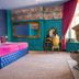 The Coal Exchange Hotel Cardiff room with blue tufted bed, ornate mirror, gold chair and pink curtains