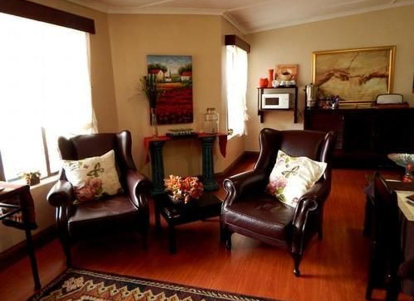 Oak Rest Guesthouse, Kimberley lounge with leather armchairs, fireplace and artwork