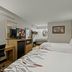 Red Roof Inn Greensboro Airport room in Greensboro with two beds, desk, TV, mini fridge and mirror