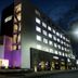 Medano Hotel and Spa in Cabo San Lucas exterior at night with illuminated windows and entrance