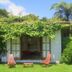 Sans Souci Inn, Pohara: lush garden cottage with open patio and chairs