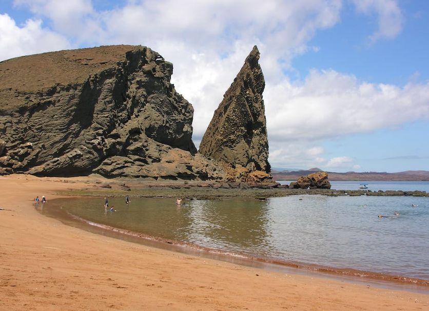 Hotel Twin Galápagos in Puerto Ayora near a sandy beach, calm bay, and dramatic rock formation