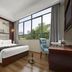 Wansheng Business Hotel Changsha guest room with large window, city view, desk, and upholstered chair