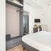 Yourhome - Villa Sorrento room in Meta with open wardrobe, white bed, and balcony view to palm trees
