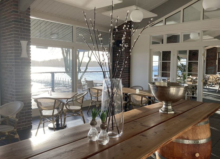 Christiansminde in Svendborg lounge with wooden tables and chairs overlooking the water