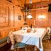 Cozy wood-paneled dining room at Familien- & Vitalhotel Auenhof in Fulpmes with set table and bench seating.