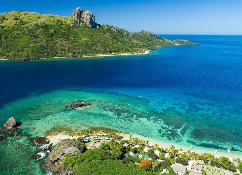 Barefoot Kuata Island on Kuata Island with turquoise bay, beach, and green mountain backdrop