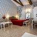 Hotel Ca' Nobile Corner Venice guest room with red bedspread, sofa and vanity mirror