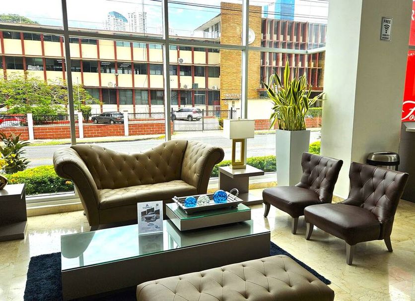 Ramada Plaza Panama Punta Pacifica lobby seating area with tufted chairs, sofa, coffee table and street view