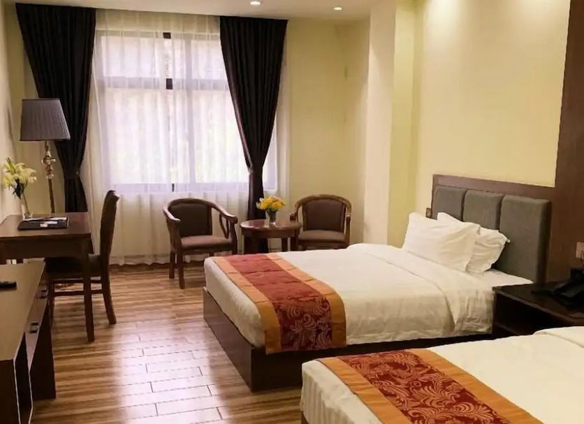 Hotel Tugos, Baguio guest room with two beds, desk, chairs, and a window with curtains