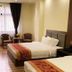 Hotel Tugos, Baguio guest room with two beds, desk, chairs, and a window with curtains