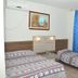 Hotel Blue Star II in Foz do Iguaçu: twin room with patterned beds, blue curtains and wall art