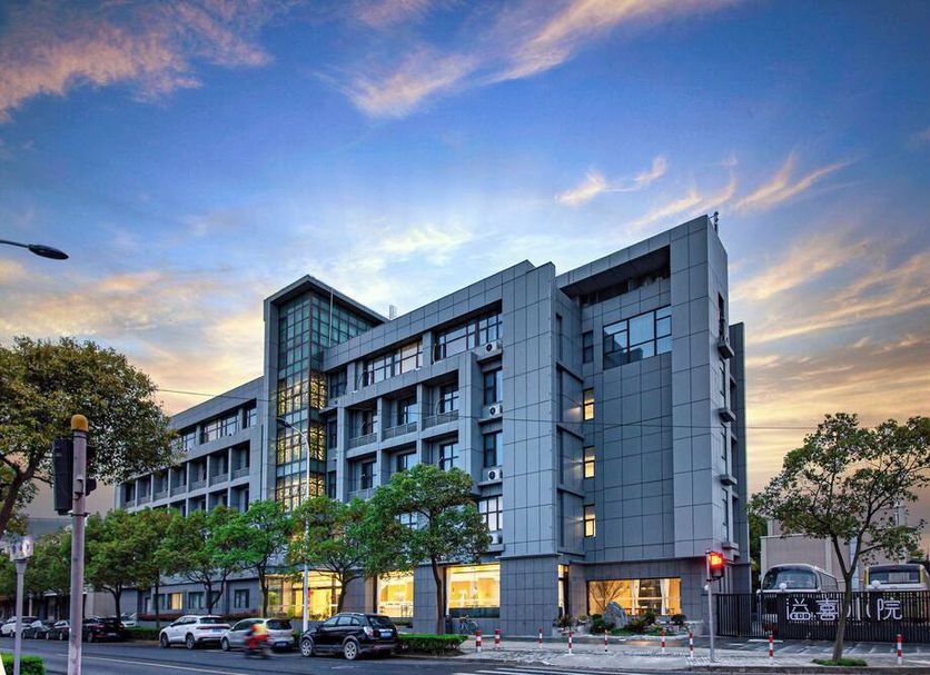 Shanghai Joyful Yard Hotel in Shanghai, modern street-facing hotel building at dusk