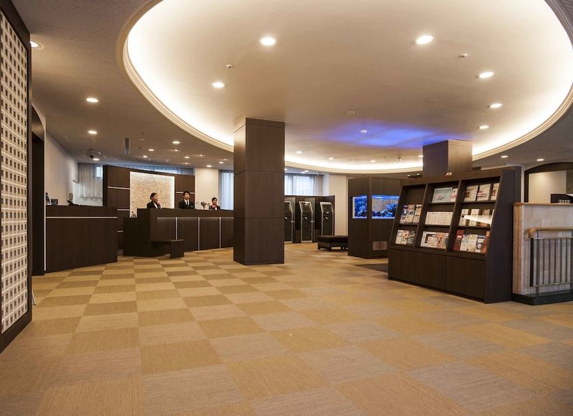 Richmond Hotel Naha Kumoji lobby in Naha with curved ceiling lights, front desk, and brochure display