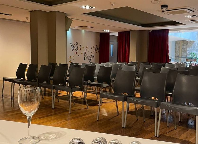 Kenton Palace Buenos Aires meeting room with rows of black chairs and a wooden floor in Buenos Aires