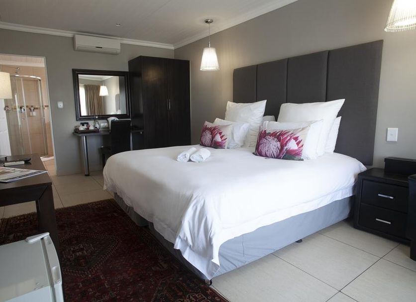 Ruslamere Hotel and Conference Centre in Durbanville: modern guest room with king bed, desk, wardrobe and hanging lights