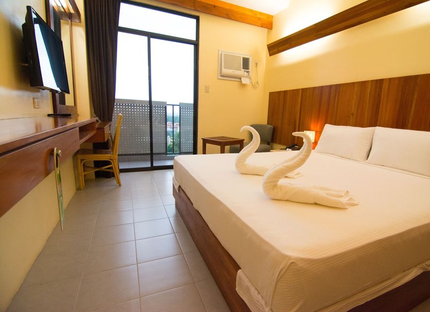 Tsai Hotel And Residences Cebu City room with double bed, swan towels, balcony and city view