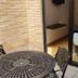 Hotel Dorado Ferial Bogotá patio with round table, chairs, and room entry through glass door