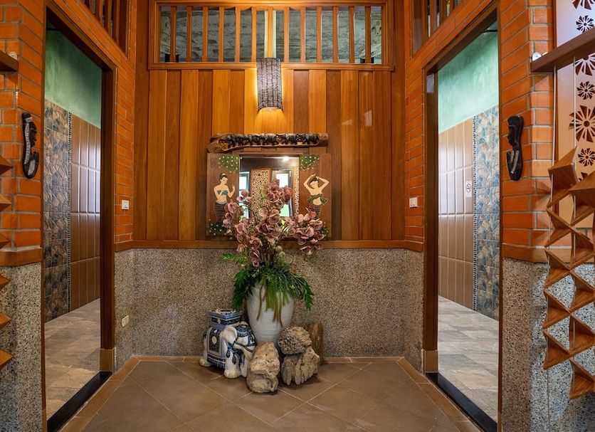 Baan Sailom Hotel Phuket - Sha Extra Plus lobby with wooden decor and floral centerpiece in Karon