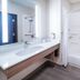 Holiday Inn Express & Suites Dumas by IHG bathroom with vanity, mirror, and accessible tub shower