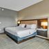 Hampton Inn Buffalo - Amherst guest room with king bed, nightstands and modern gray walls in Amherst