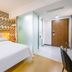 Shanshui Trends Hotel Shao Yao Ju Beijing guest room with bed, frosted glass partition and wooden door