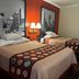 Super 8 by Wyndham Brookshire TX guest room with two double beds and cityscape wall art