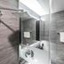 Jamsil Stay Hotel Seoul bathroom shower with glass partition, rainfall showerhead and gray tile walls