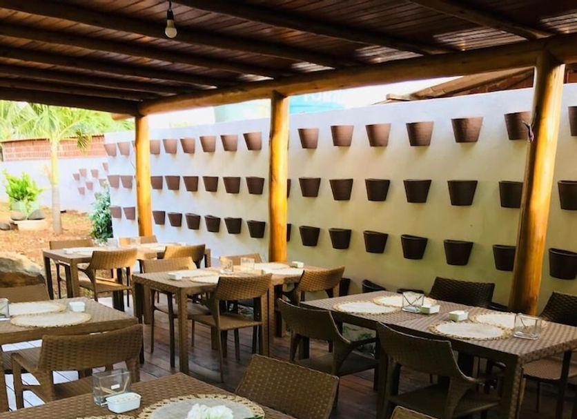 Pousada Recanto in Fernando de Noronha, outdoor breakfast dining area with wicker tables and chairs