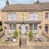The Lawrence, Burnley: stone hotel exterior with front terrace seating and hanging flower baskets