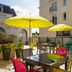 Hôtel Mercure Trouville-sur-Mer terrace with yellow umbrellas and colorful chairs in Trouville-sur-Mer