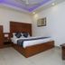Vishal Hotel Near New Delhi Railway Station room with wooden bed, bedside cabinet and ceiling fan in New Delhi