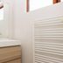 Guesthouse Brekka, Husavik: modern bathroom with wood vanity, mirror, sink and white towel radiator