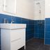 Media Luna Guesthouse bathroom in Seydisfjordur with white sink vanity, blue tile walls, and shower