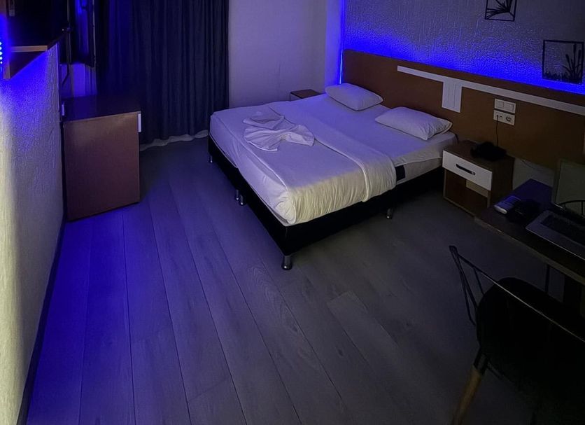 Avcilar Inci Hotel Istanbul room with double bed, blue LED lighting, desk, and curtains